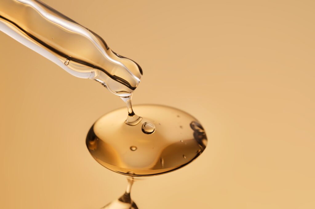 A pipette with a beautiful drop of gel-textured facial serum.